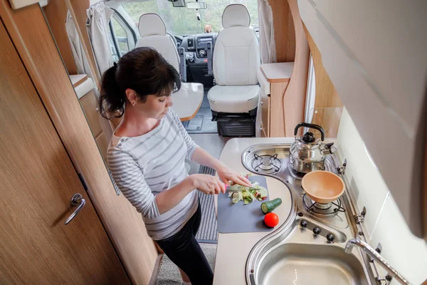 Woman cooking in camper, motorhome interior — Stock Photo, Image