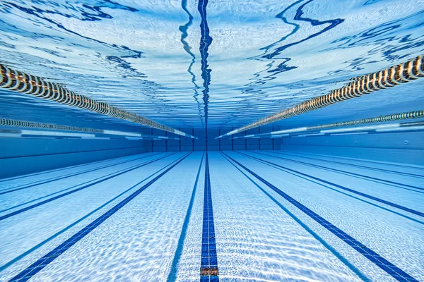 水の背景の下でオリンピックスイミングプール. — ストック写真