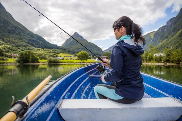 Mulher pesca na vara de pesca girando na Noruega . — Fotografia de Stock