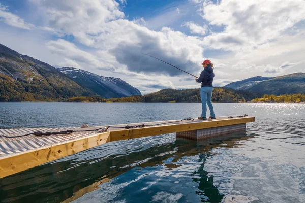 Mujer pescando en caña de pescar spinning en Noruega . — Foto de Stock