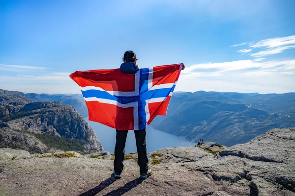 Frau mit schwenkender norwegischer Flagge vor dem Hintergrund der Natur — Stockfoto