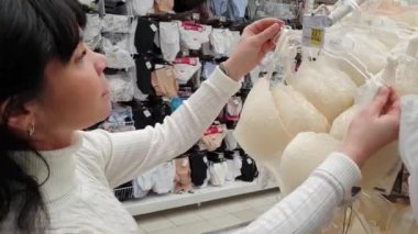 Alışveriş merkezinde kadın alışverişi. İç çamaşırı seçmek, sutyen.