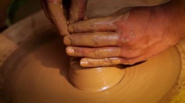 Potter iş yerinde seramik yemekler yapıyor. Hindistan, Rajasthan.