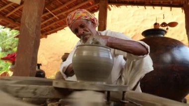 Potter iş yerinde seramik yemekler yapıyor. Hindistan, Rajasthan.