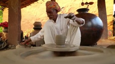 Potter iş yerinde seramik yemekler yapıyor. Hindistan, Rajasthan.