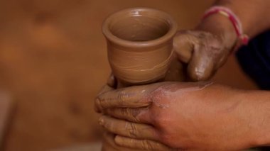 Potter iş yerinde seramik yemekler yapıyor. Hindistan, Rajasthan.