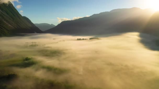 Morgennebel über dem Tal zwischen den Bergen im Sonnenlicht. Nebel und die schöne Natur Norwegens aus der Luft. — Stockvideo