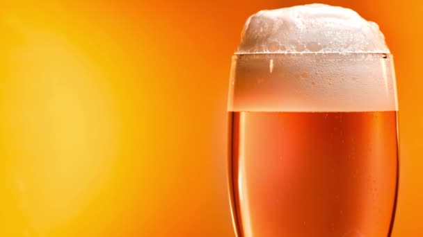 Lager öl lägger sig i glaset med en vit lock av skum — Stockvideo