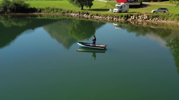 Žena na lodi chytí rybu na rotaci v Norsku. — Stock video