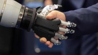 Android bir robotla el sıkışan bir iş adamının eli. Yapay zekayla insan etkileşimi kavramı.