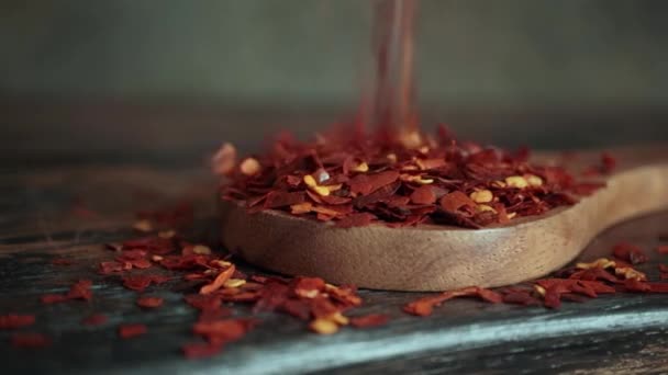 Flocken Roter Chilischote Holzlöffel Nahaufnahme Auf Einem Küchentisch — Stockvideo
