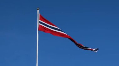 Norveç bayrağı dalgalanıyor derin mavi gökyüzüne doğru.