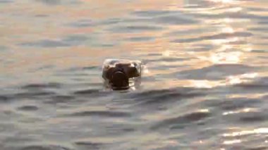 Şişedeki mesaj güneşe karşı batıyor.