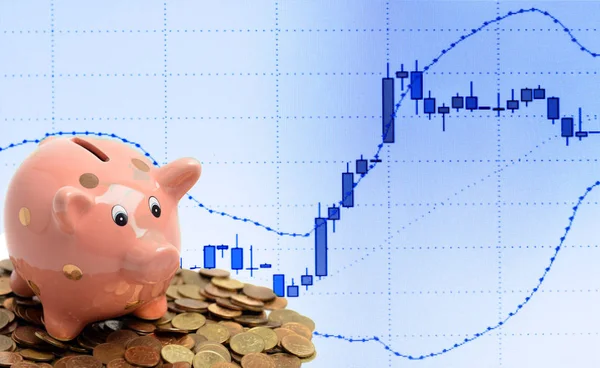 硬币小猪银行和商业蜡烛图在电脑屏幕上的股票市场投资交易 — 图库照片