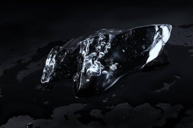 Eriyen buz parçası üzerinde siyah