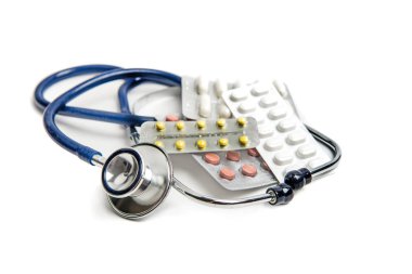 Stetoskop ve beyaz üzerinde haplar 