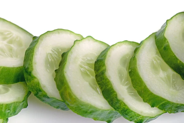 Verse komkommerplakjes golfvormig geïsoleerd — Stockfoto