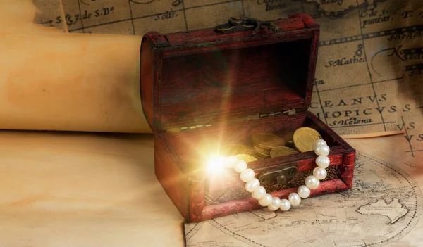 Pirate chest on vintage maps and scrolls  with sparkling treasur — Stock Photo, Image