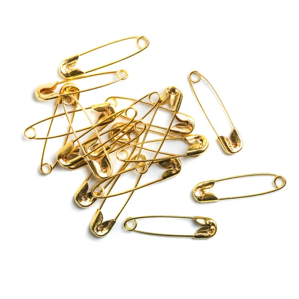 Golden colored safety pins on white background. — Stock Photo, Image
