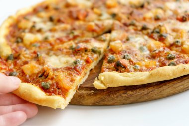 Dilimlenmiş İtalyan pizzası ve beyaz arka planda deniz ürünleri.