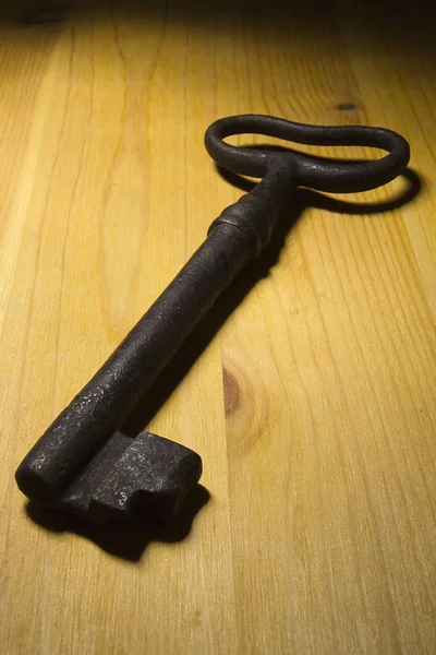 木桌上的一把生锈的旧钥匙 — 图库照片