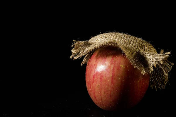 Manzana Una Tapa Arpillera Sobre Fondo Negro —  Fotos de Stock