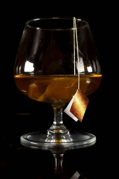 Cognac Glas Met Een Tas Thee Een Zwarte Achtergrond — Stockfoto