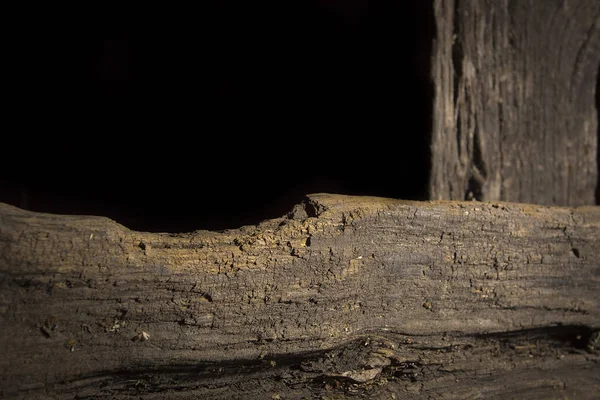 黒の背景に梁に積み上げられた古い腐った丸太 — ストック写真