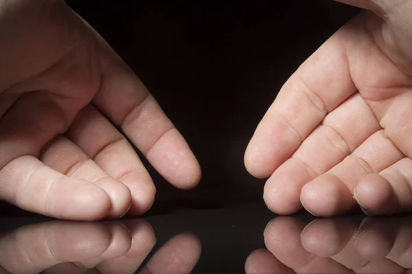 Mãos em uma superfície reflexiva — Fotografia de Stock