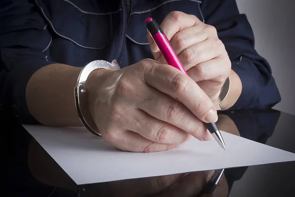 Kvinnliga händer i handfängsel skriva — Stockfoto