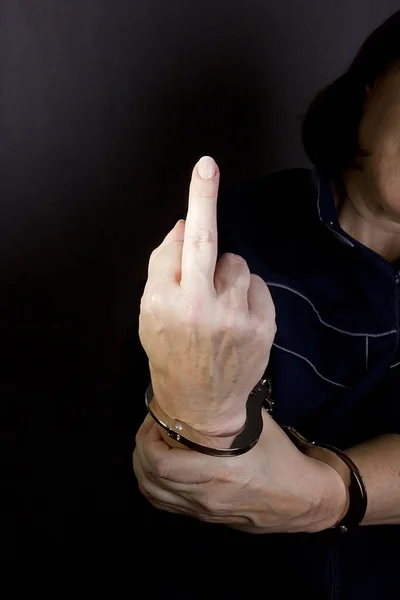 Handcuffed hands with middle finger raised. — Stock Photo, Image