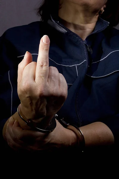 Handcuffed hands with middle finger raised. — Stock Photo, Image