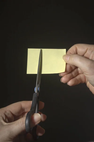 Manos con tijeras y una hoja de papel — Foto de Stock