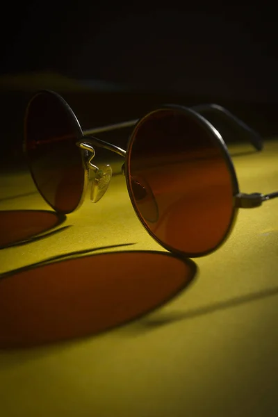 Okrągłe okulary przeciwsłoneczne na żółtej powierzchni — Zdjęcie stockowe