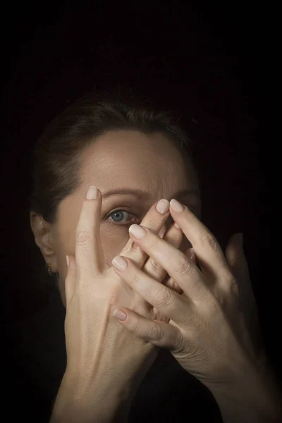 Woman covers her face with hands.