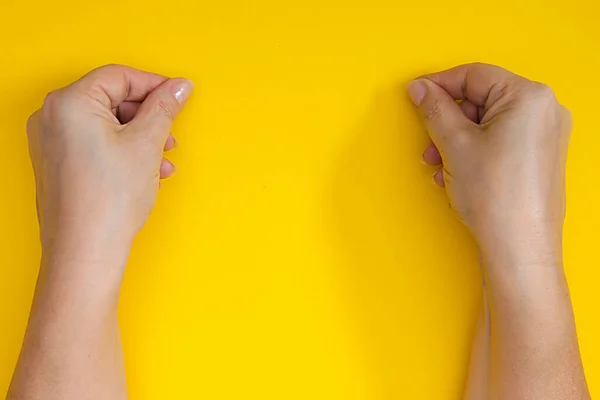 Mains Serrées Dans Une Pincée Sur Fond Jaune — Photo