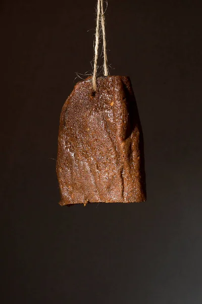 Carne Seca Colgada Una Cuerda Contra Una Pared Negra —  Fotos de Stock