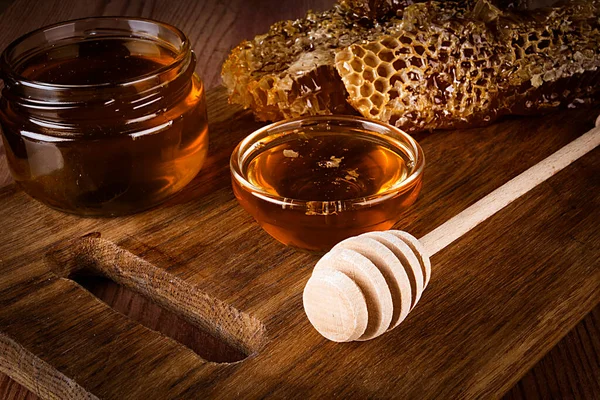 木製のテーブルの上に黄色の蜂蜜とハニカムスライス — ストック写真