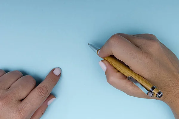 Ручка Жіночих Руках Синьому Фоні — стокове фото