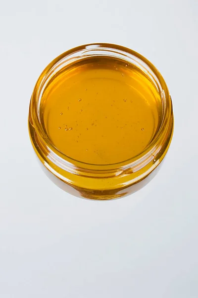 白色背景的玻璃器皿中的蜂蜜 — 图库照片