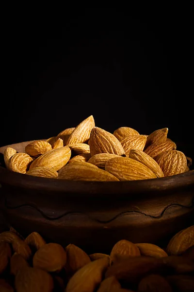 Nueces Almendras Secas Plato Arcilla Sobre Fondo Negro —  Fotos de Stock