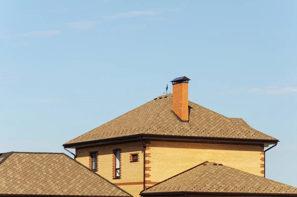 青い空を背景に新しい郊外のレンガの屋根の家します — ストック写真