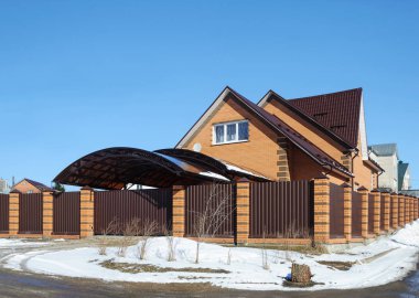 Kırmızı tuğla yazlık witn garajın arkasında küçük Rus kasabada, bahar zaman metal çit