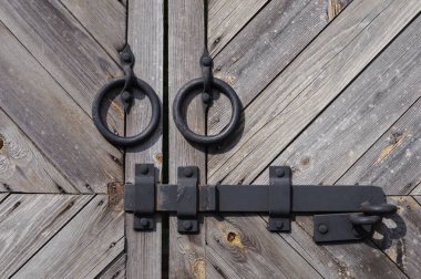 İki siyah demir yüzük ve cıvata ile eski ahşap kapı closeup