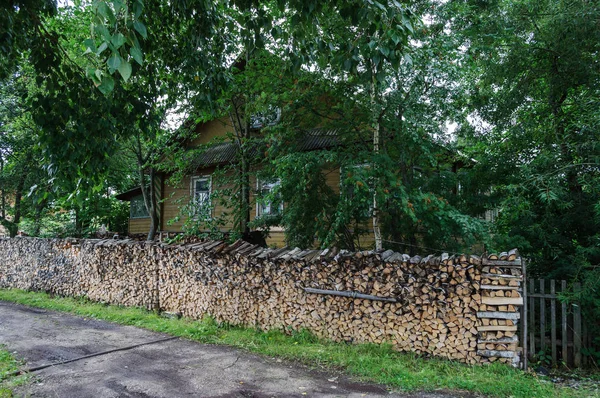 Pile de grumes devant la maison dans le pays — Photo