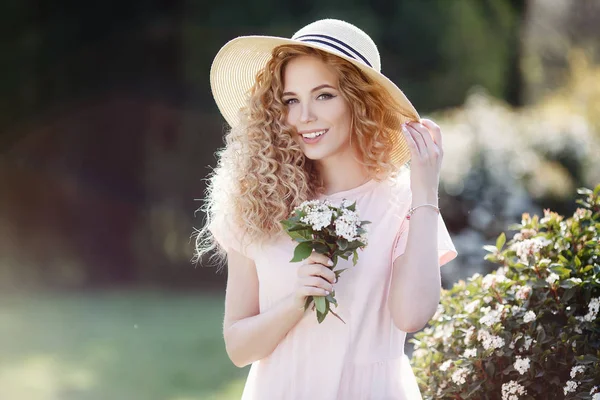 夏の花公園で髪型の花で美しい若いモデル春の少女 ブルーミング ガーデンの女性 ファッション 化粧品 Perfumes Portrait スプリング パーク屋外で巻き毛の美しい女性の — ストック写真