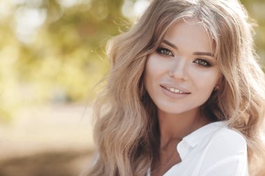Bir bahar parkta açık havada kıvırcık saçlı güzel bir kadın portresi. Portre hülyalı ve hava çekici kız oynak ve kaygısız güneşli güzel gülümseme ile olmak. Sağlıklı açık havada bir yaşam tarzı. Mutlu kadın portre yaz veya bahar gün ou