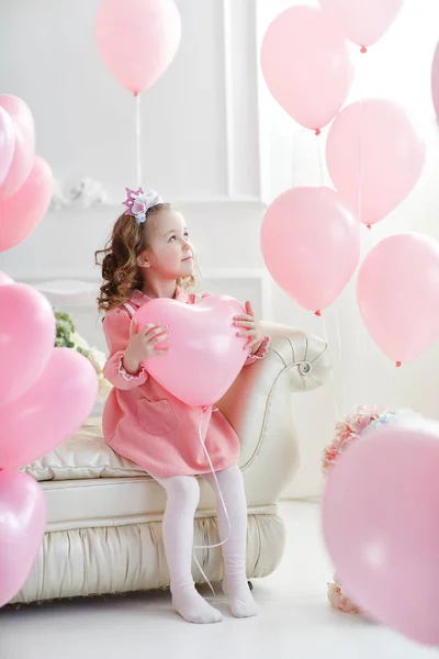 バレンタインの日 ポストカード 金髪巻き毛の小さな女の子は ピンクの風船に囲まれた白いスタジオでポーズします ハートのピンクの風船と白いスタジオで美しい幼児少女 バレンタインの日 誕生日 — ストック写真