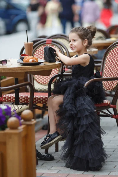 Nettes Kleines Mädchen Einem Schönen Schwarzen Abendkleid Das Einem Tisch — Stockfoto