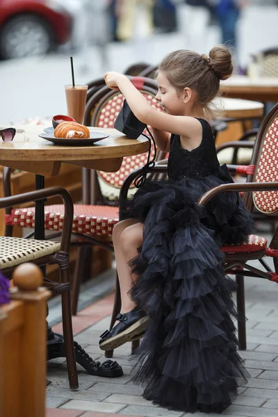 Nettes Kleines Mädchen Einem Schönen Schwarzen Abendkleid Das Einem Tisch — Stockfoto